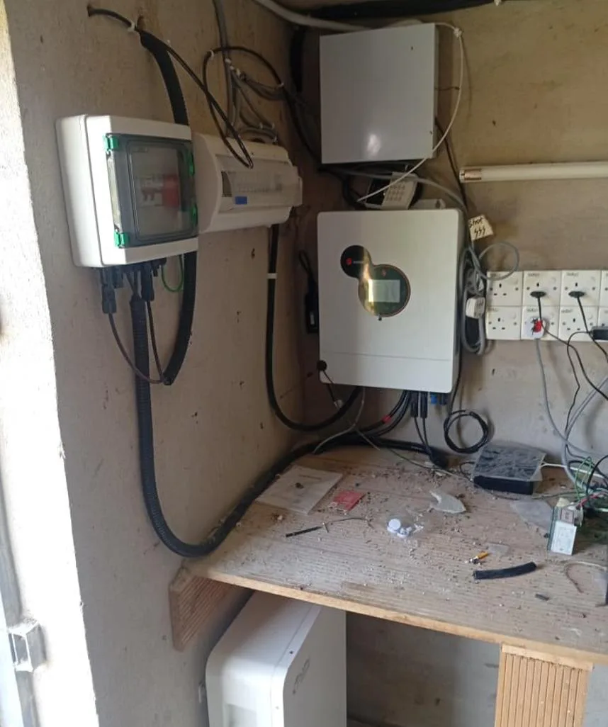 Off-grid inverter, distribution box and battery installed on the wall of a small room