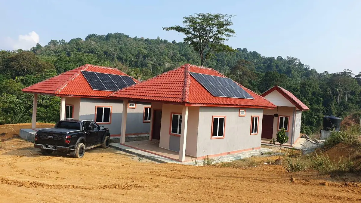 Two single-storey houses with red roofs and rooftop solar panels on a cleared hillside site