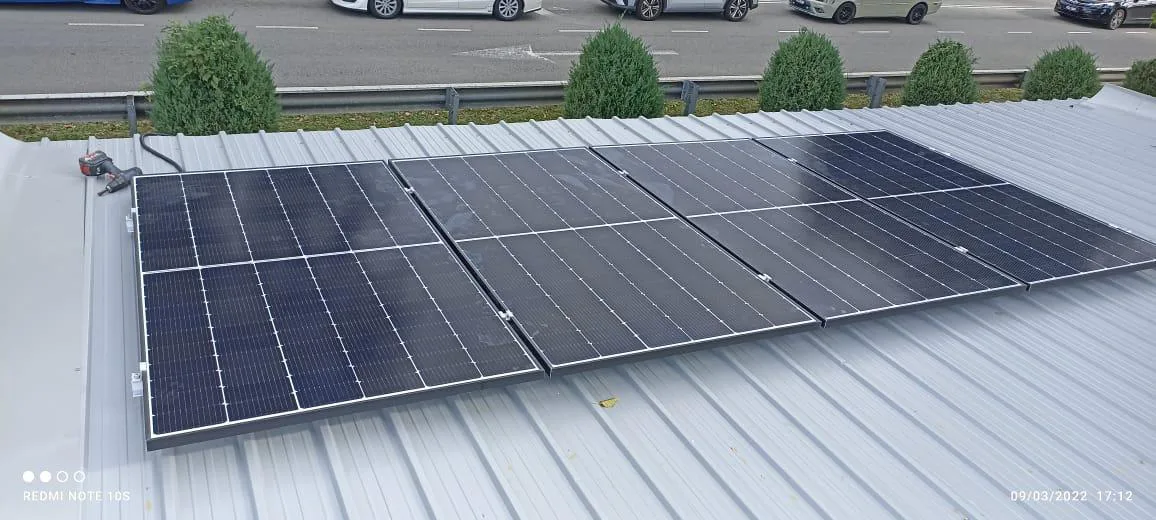 Solar panels on a metal roof beside a highway