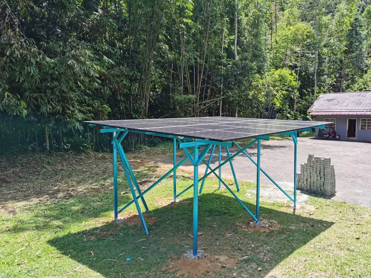 Ground-mounted solar array on a raised steel frame in a forest clearing